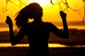 Silhouette of a female in headphones, the girl enjoying music on the sunset
