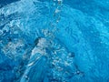 Dynamic splash in crystal clear blue water and glass bottle, creating ripples and water droplets in motion. Clean water Royalty Free Stock Photo