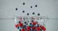 Dynamic Splash of Fresh Blueberries and Strawberries in Clear Water Royalty Free Stock Photo