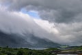 Dynamic summer sky in Norway above mountains and foliage, caressed by mist near the Arctic Circle