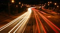 Dynamic urban nightscape blurred car lights in high speed traffic on illuminated city highway Royalty Free Stock Photo