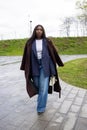 Dynamic Urban Walk: Fashion-Forward Woman in Layered Autumn Wear Royalty Free Stock Photo