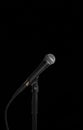 Dynamic vocal microphone on a stand with black background