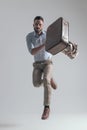 Dynamic young businessman holding bag and jacket while jumping Royalty Free Stock Photo