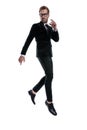 Dynamic young man in black suit jumping in the air Royalty Free Stock Photo