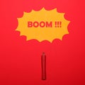 Dynamite stick with BOOM sign above on red background - Explosion concept - Minimal design