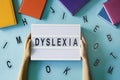 Dyslexia awareness, help children with reading, learning difficulties concept. Kid hand holding lightbox with DYSLEXIA