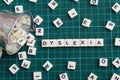 Dyslexia word made of square letter word on green square mat background.