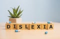 Dyslexia Word Written In Wooden Cube, dislexia concept.