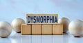 DYSMORPHIA - word on wooden cubes on a light background with balls