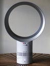 Dyson Cool AM06 white desk fan placed on circular wooden table