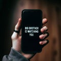 Dystopian Surveillance: Hand Holding Phone with \'Big Brother is Watching You\' Text - AI Generated Image