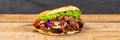 DÃÂ¶ner Kebab Doner Kebap fast food in flatbread on a wooden board panorama