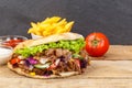 DÃÂ¶ner Kebab Doner Kebap fast food meal in flatbread with fries on a wooden board and copyspace copy space