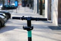 Closeup of isolated e-scooter handlebar, blurred city street background