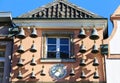 View on old house facade with many antique bells and clock against blue sky