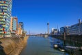 View over water canal beyond modern buildings on rhine tower against blue sky