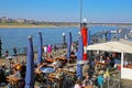 View on outside restaurant, sitting people on sunny winter day, Oberkasseler bridge rhine river background