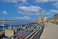 View on rhine riverside promenade with cafe restaurants on clock tower against blue sky