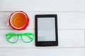 E-book, glasses and a cup of tea on a white background. Top view Royalty Free Stock Photo