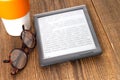 e-book reader and glasses on a wooden table Royalty Free Stock Photo