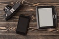 E-book reader, smartphone close-up on wooden background Royalty Free Stock Photo