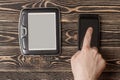 E-book reader, smartphone close-up on wooden background Royalty Free Stock Photo