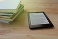 E-book reader and stack of books on wooden Royalty Free Stock Photo