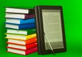 E-book reader with stack of printed books