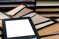 An e-book with a white screen and a place for text is on a shelf with books Royalty Free Stock Photo