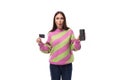 e-business concept. 35 year old feminine model woman dressed in a pink and green pullover holding a credit card mockup