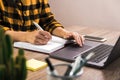 Side close up view hands of student, freelancer or office worker writing in notebook on a desk Royalty Free Stock Photo