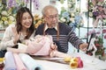 Asian florists family demonstrate flower arrangements via online live streaming.