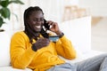 E-commerce Concept. Cheerful Young Black Man Holding Credit Card And Using Cellphone Royalty Free Stock Photo