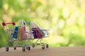 E-commerce concept: Paper shopping bags in a trolley or shopping cart with an icon linking business plans in the natural green Royalty Free Stock Photo