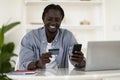 E-Commerce Concept. Smiling Black Man Holding Credit Card And Using Cellphone Royalty Free Stock Photo