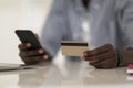 E-Commerce Concept. Unrecognizable African American Man Using Smartphone And Credit Card Royalty Free Stock Photo