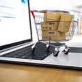 E-commerce. Shopping cart with cardboard boxes on laptop. Royalty Free Stock Photo
