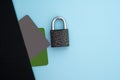 E-commers, banking. Black and green bank credit, debit card and metal lock on a blue background. Flat lay, top view. Royalty Free Stock Photo