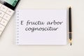 E fructu arbor cognoscitur the phrase in Latin translates as the Tree is known by its fruits on a white notebook
