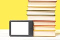 E-learning. E-book reader and a stack of books on a yellow background. Mock up. Copy space. Concept of education and electronic