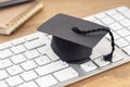 E-Learning or home study concept. Graduation cap on computer keyboard Royalty Free Stock Photo