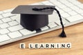 E-Learning or home study concept. Graduation cap on computer keyboard Royalty Free Stock Photo