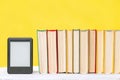 E-learning and knowledge. E-book reader and a stack of books on a yellow background. Copy space. Mock up. Concept of education and Royalty Free Stock Photo