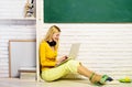 E-learning. Lesson and education in high school. Smiling student girl sitting on floor preparing for test or exam at Royalty Free Stock Photo