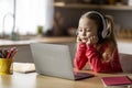 E-Learning Problems. Bored Little Girl In Wireless Headphones Looking At Laptop Screen Royalty Free Stock Photo