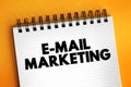 E-mail Marketing - act of sending a commercial message to a group of people, using email, text concept on notepad