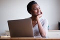 Woman resting chin on hand sitting at desk with laptop Royalty Free Stock Photo