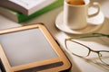 E-reader with cup of coffee and glasses