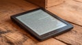 E-reader on a rustic wooden table displaying text, showcasing technology Royalty Free Stock Photo